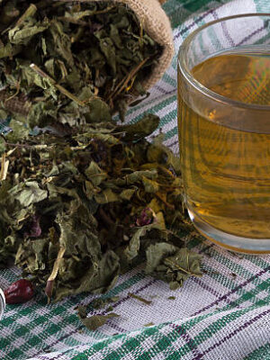 Cup and dried herbal tea on wooden table.