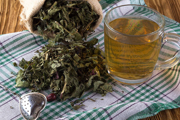 Cup and dried herbal tea on wooden table.