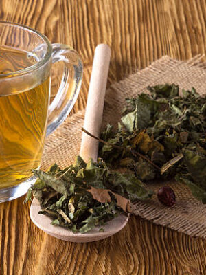 Cup and dried herbal tea on wooden table.