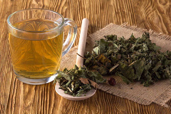 Cup and dried herbal tea on wooden table.