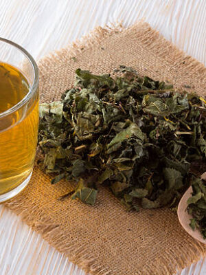 Cup and dried herbal tea on wooden table.